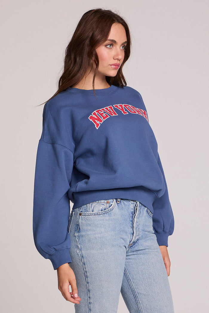 Front view of a woman wearing the Chaser New York Long Sleeve on a neutral background with jeans