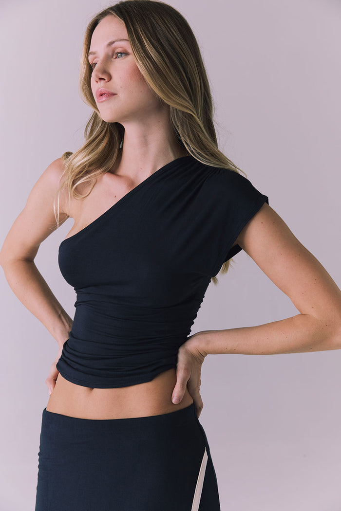 3/4 angle of the Nice Tank in Licorice Black highlighting the asymmetrical shoulder and smooth fitted shape