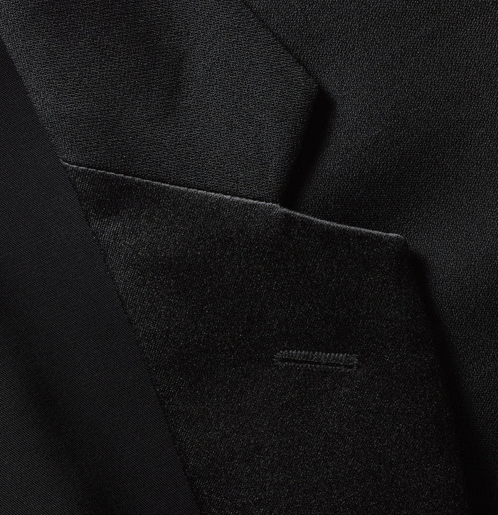 Close-up of black tuxedo jacket lapel and buttonhole detail with satin trim