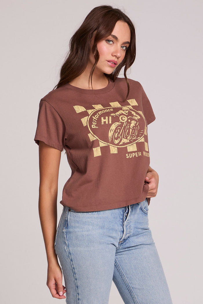 Side angle view of a woman wearing the Chaser Off Road Race Team Graphic Tee and jeans on a neutral background