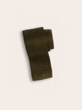 Olive green knit silk tie rolled into a coil on cream background