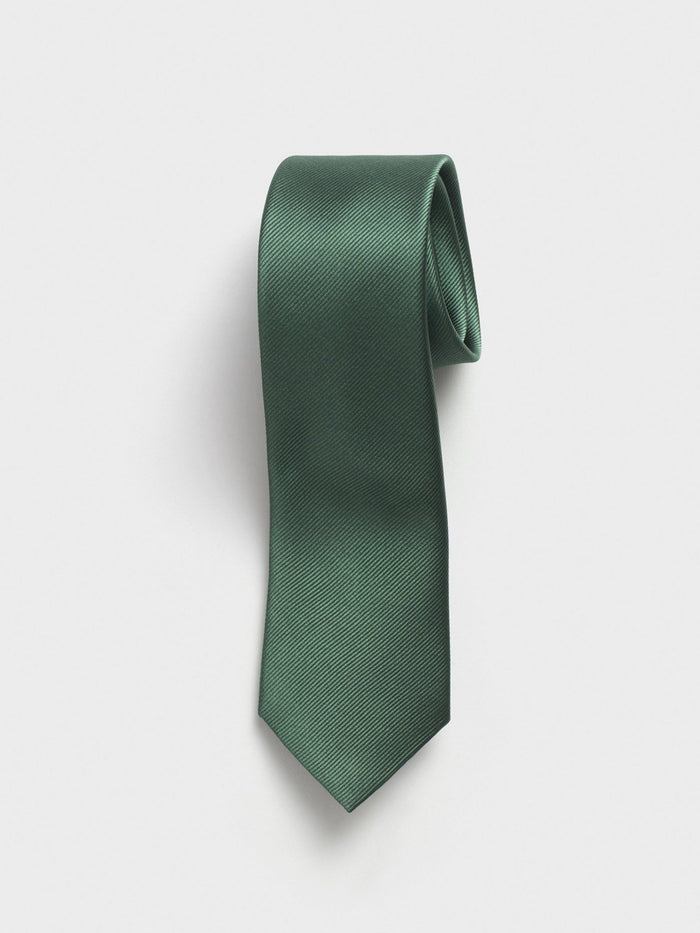 Olive green silk necktie rolled into a coil on light grey background