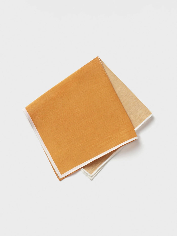 Orange quad pocket square folded, showing orange and beige sides, on white background