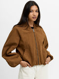 A woman wearing a brown suede Bomber jacket with long batwing sleeves, a zip through fastening, a ribbed bomber collar and 2 side pockets.