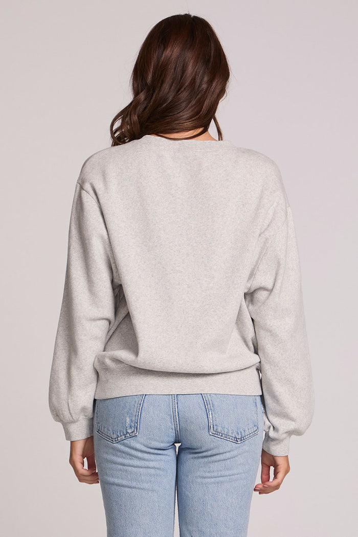 Back view of a woman wearing the Chaser Paris is For Tee on a neutral background with jeans