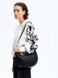 Woman wearing a white knitted jumper with black floral embroidered balloon sleeves