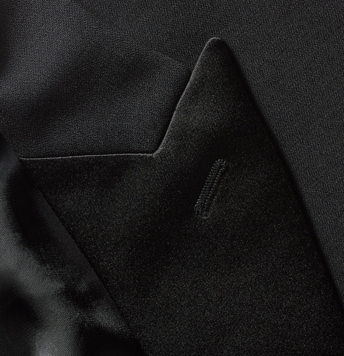 Close-up of black tuxedo jacket pocket flap and peak lapel detail