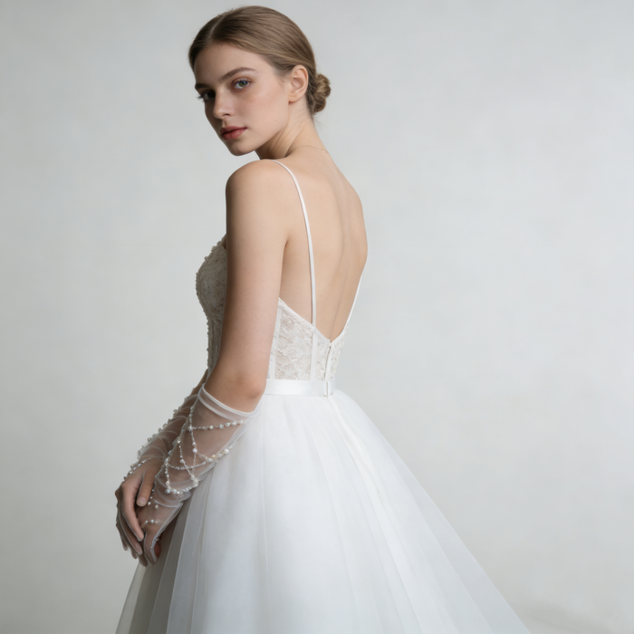 Full-length bridal gown styled with handcrafted pearl beaded tulle gloves creating an elegant wedding look.