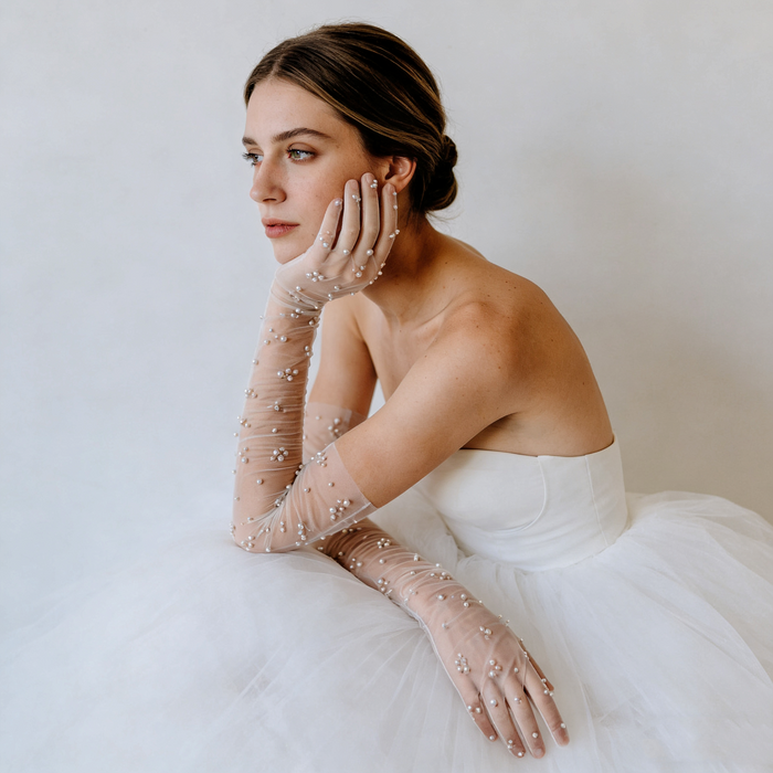 Bride wearing pearl embellished illusion tulle opera gloves with a modern wedding gown during a romantic bridal photoshoot.