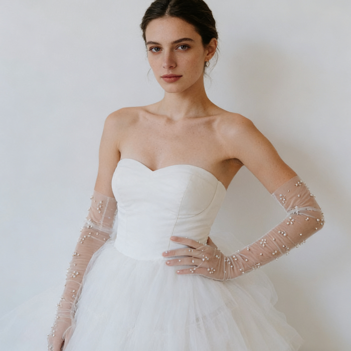 Bride wearing pearl embellished illusion tulle opera gloves with a modern wedding gown during a romantic bridal photoshoot.