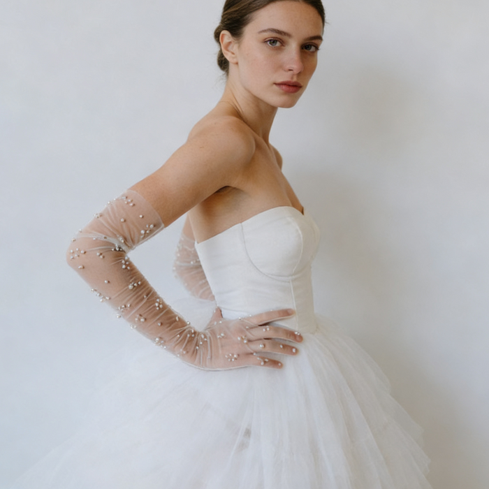 Bride wearing pearl embellished illusion tulle opera gloves with a modern wedding gown during a romantic bridal photoshoot.