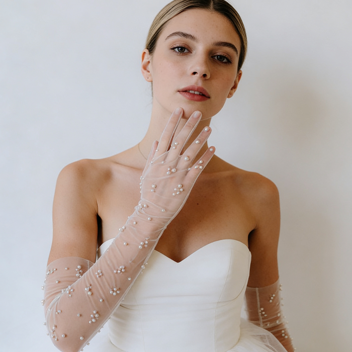 Bride wearing pearl embellished illusion tulle opera gloves with a modern wedding gown during a romantic bridal photoshoot.