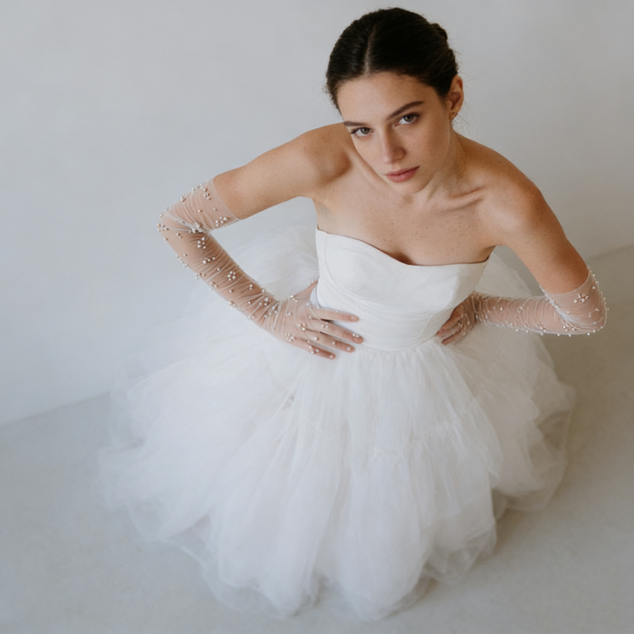 Bride wearing pearl embellished illusion tulle opera gloves with a modern wedding gown during a romantic bridal photoshoot.
