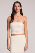 Front view of a woman wearing the Chaser Coconut Milk Tube Top and matching Catch Midi skirt on a neutral background