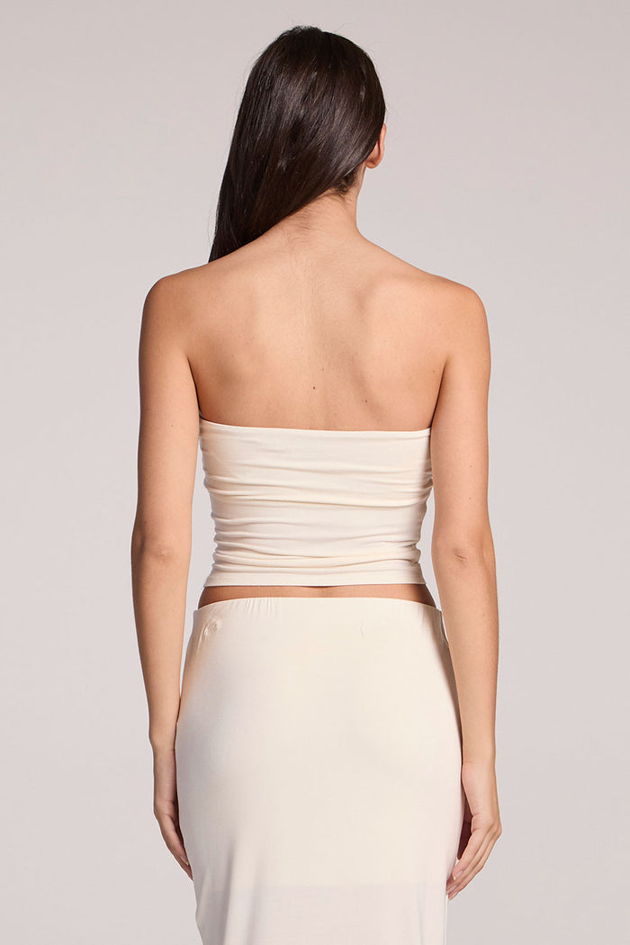 Back view of a woman wearing the Chaser Coconut Milk Tube Top on a neutral background
