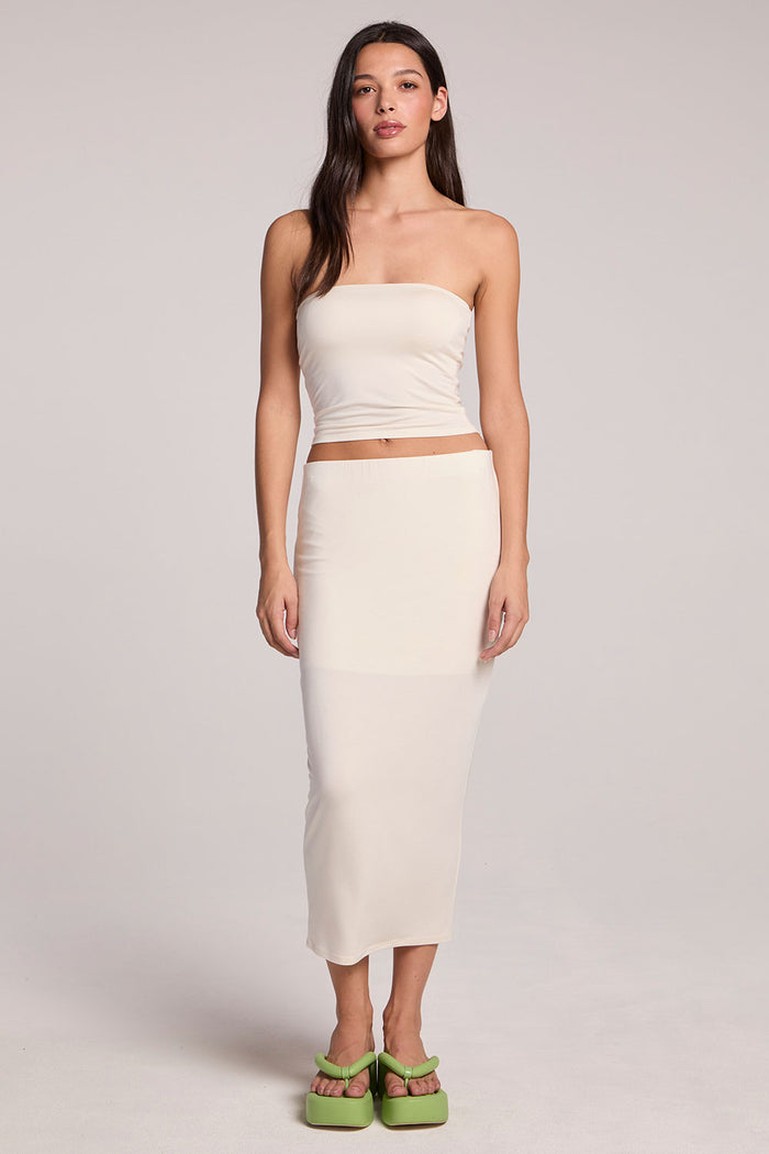 Full body view of a woman wearing the Chaser Coconut Milk Tube Top and green shoes on a neutral background