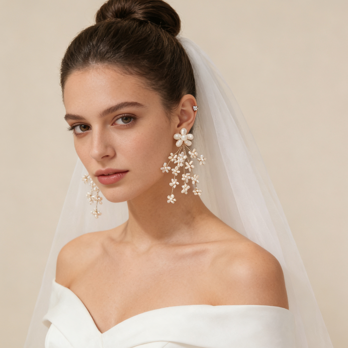Bride wearing pearl flower drop earrings with a wedding veil and elegant gown during a bridal photoshoot.