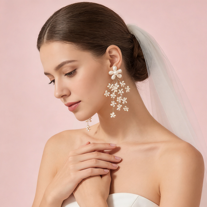 Bride wearing pearl flower drop earrings with a wedding veil and elegant gown during a bridal photoshoot.