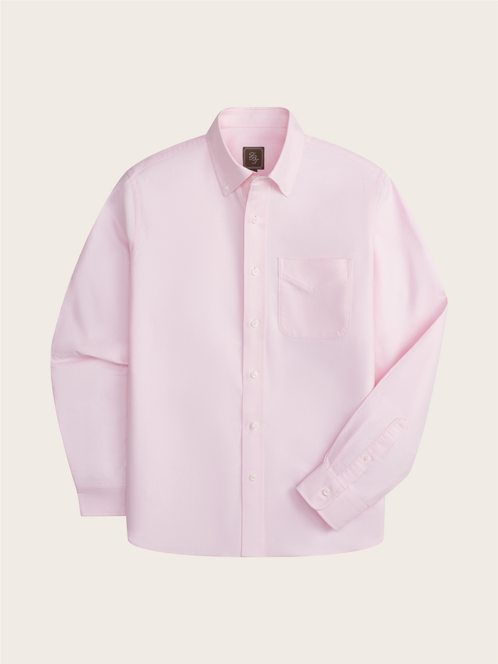 Pink oxford shirt laid flat, front view, on cream background