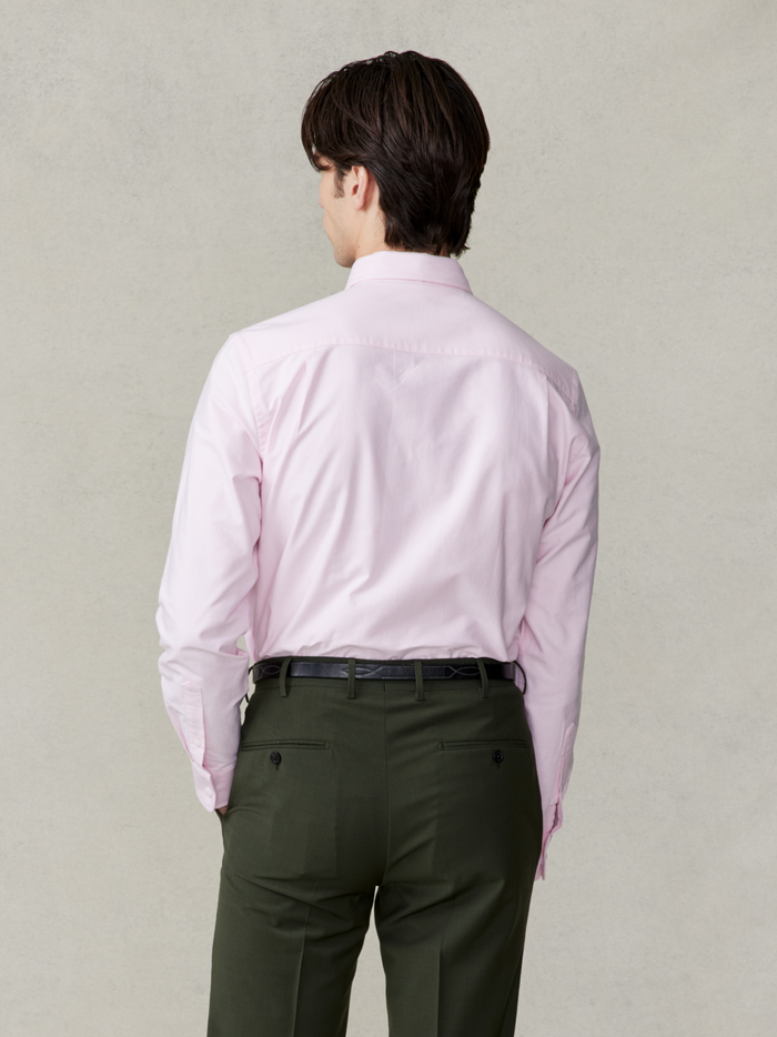 Back view of man in pink oxford shirt and olive trousers