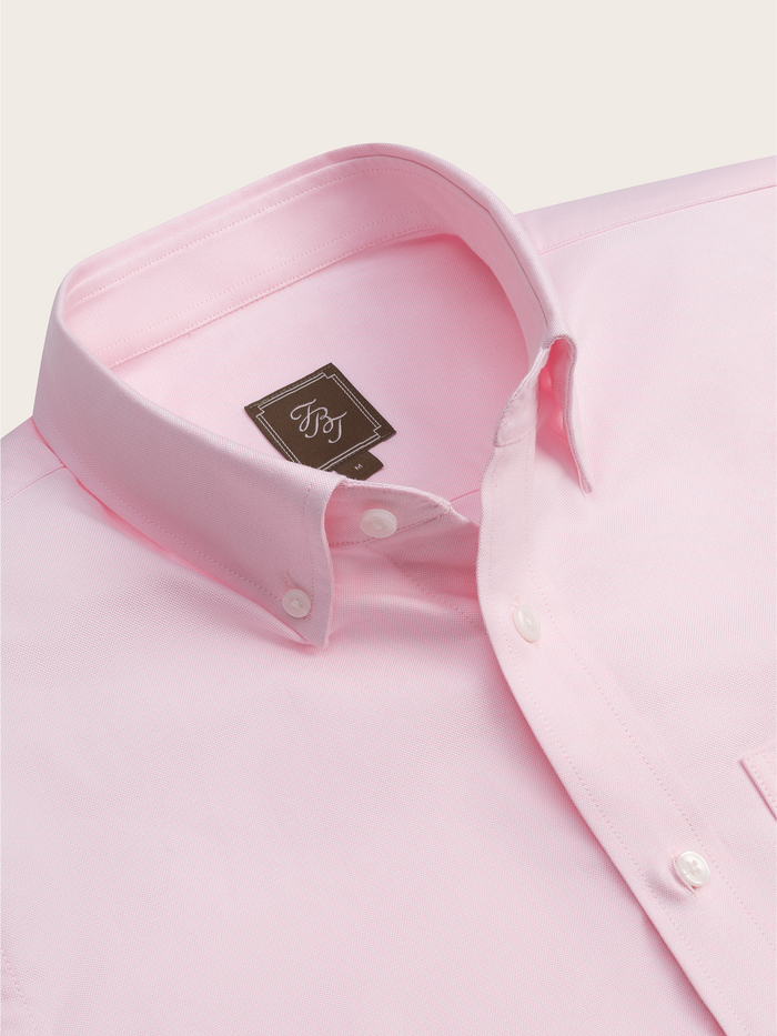 Close-up of pink oxford shirt collar and button placket with brand tag