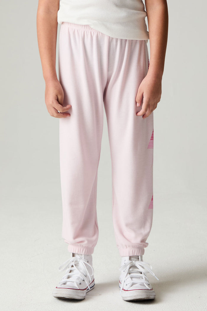 Side view of a girl wearing the Chaser Power Bolt Girls Jogger and white sneakers on a neutral background