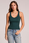 Front view of a woman wearing the Chaser  Prescot Pine Green Tank Top and jeans on a neutral background