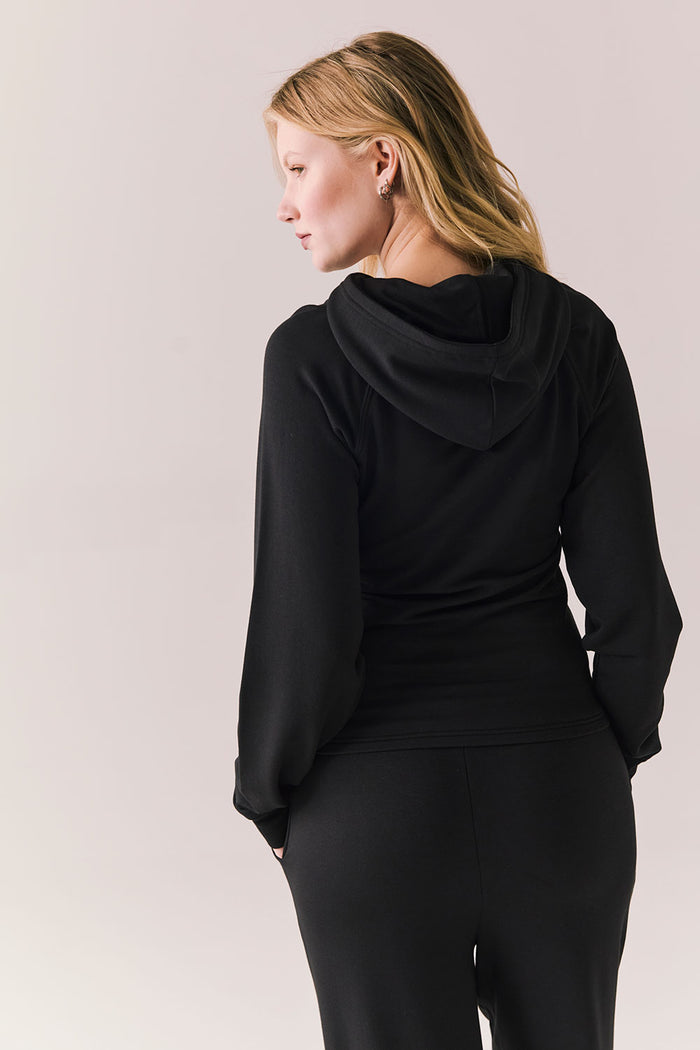 Back of black modal hoodie with no graphic and streamlined silhouette.