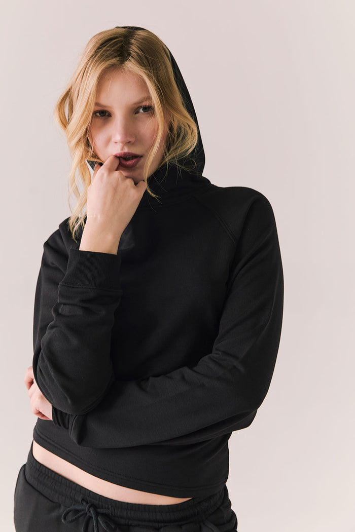 Full body view of model in black Providence hoodie styled with matching black lounge pants.