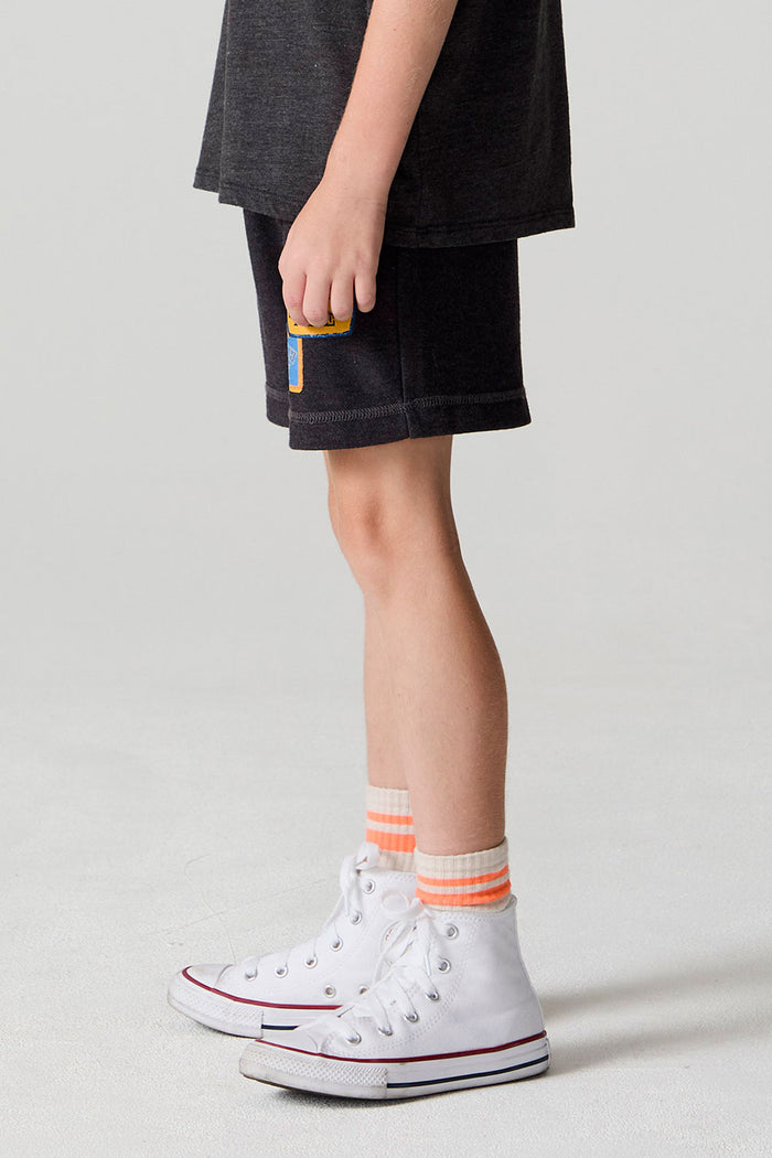 Side view of a boy wearing the Chaser Race Patches Shorts on a neutral background