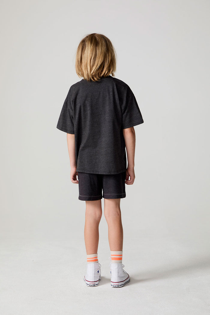 Full body back view of a boy wearing the Chaser Race Patches Tee on a neutral background