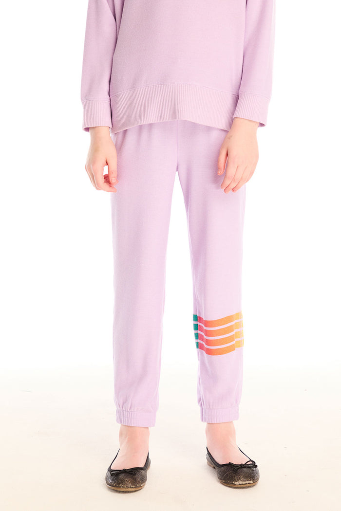 Girl wearing Chaser’s pink Rainbow Glitter Pants with rainbow heart design on a white background