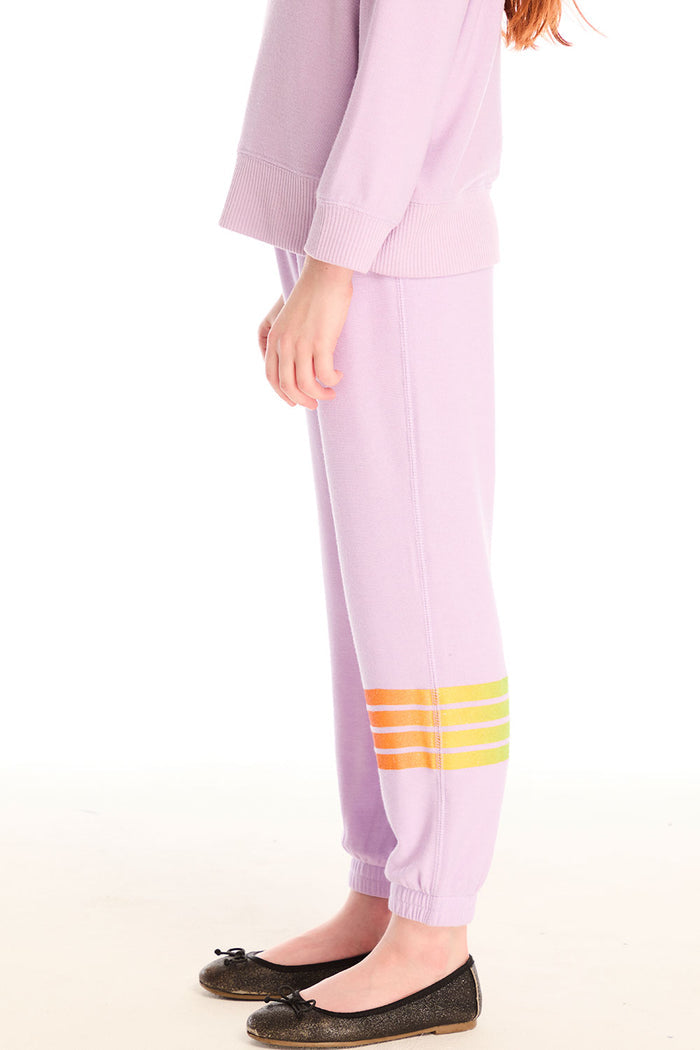 Side view of girl wearing Chaser’s pink Rainbow Glitter Pants with rainbow heart design on a white background