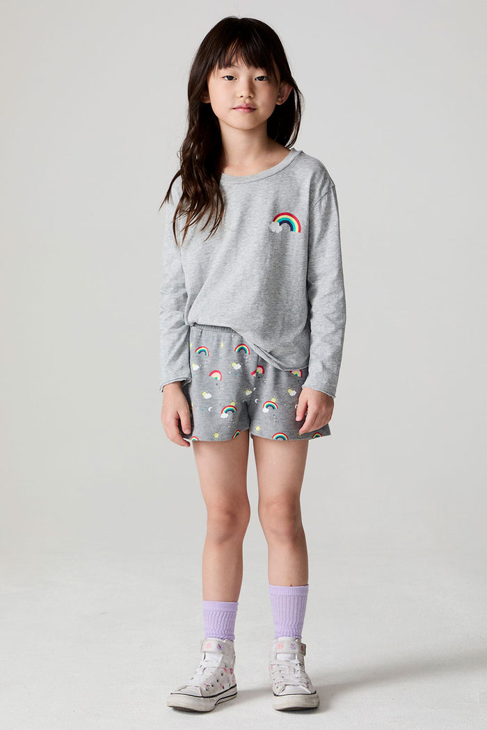 Full body front view of a girl wearing the Chaser  Rainbow Morning Allover Shorts on a neutral background