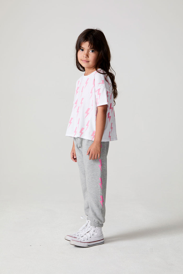 Full body side angle view of a girl wearing the Chaser Raining Bolts Tee on a neutral background
