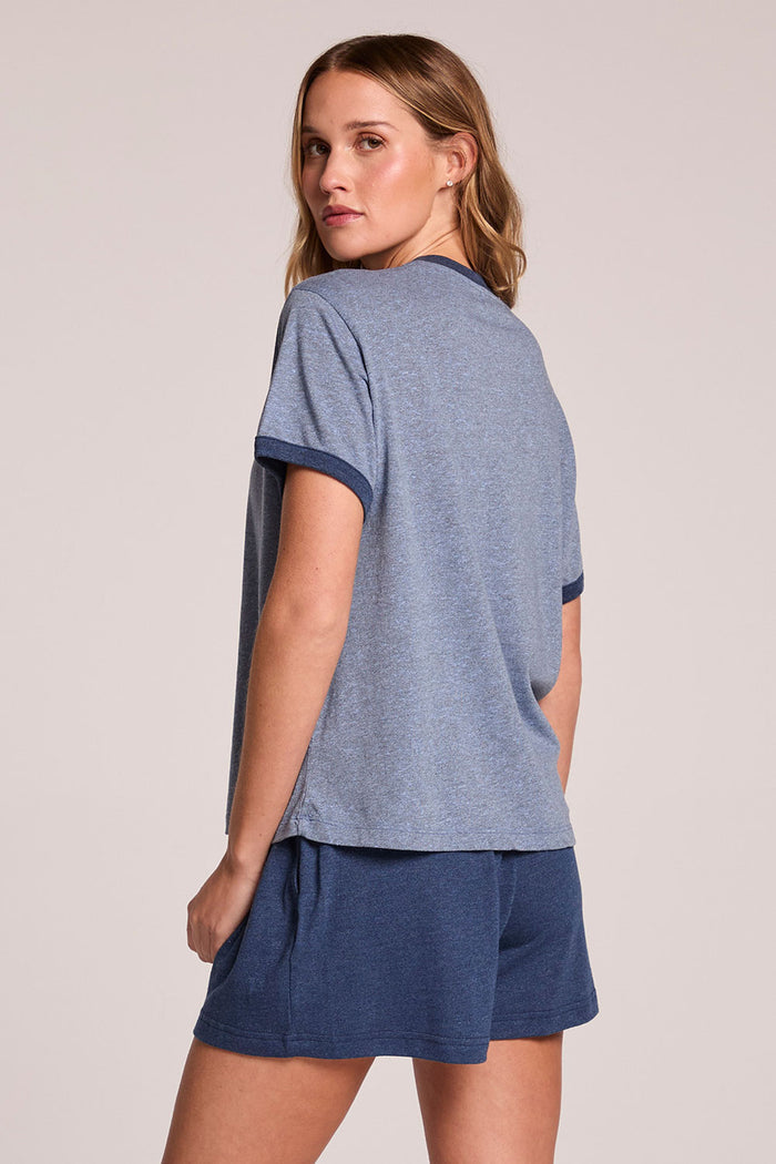 Back view of a woman wearing the Chaser  Rambler Admiral and Serenity Tee on a neutral background