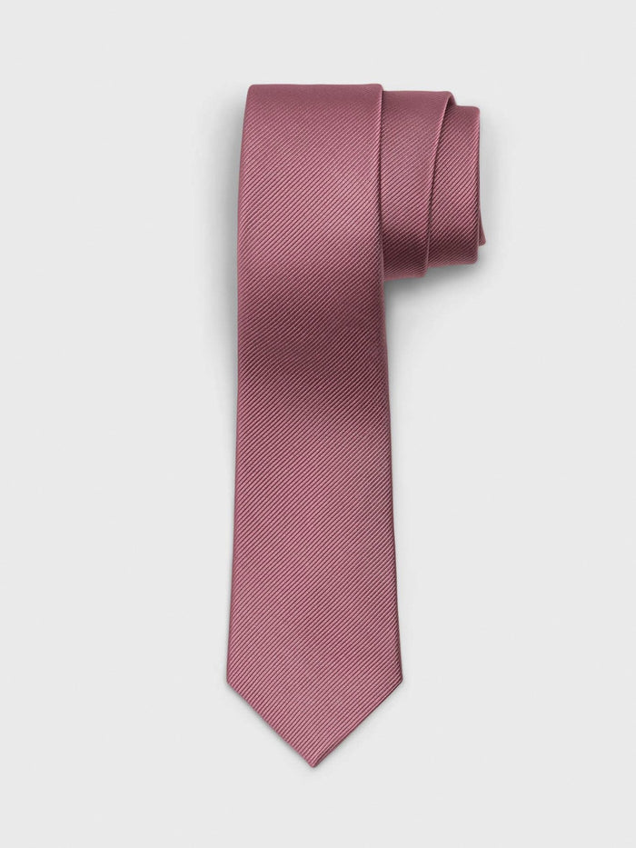 Raspberry pink silk necktie rolled into a coil on light grey background