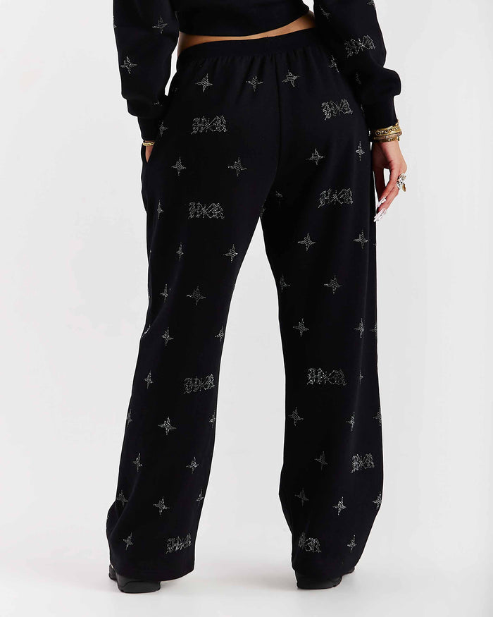 Black pants with a pattern worn by a person on a white background
