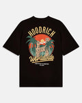 A black short-sleeve t-shirt with a large retro-style graphic on the front. The graphic features the text 'HOODRICH' in arched yellow letters above a circular illustration of a building, palm trees, and a sunset, with 'Worldwide' written in yellow script below.
