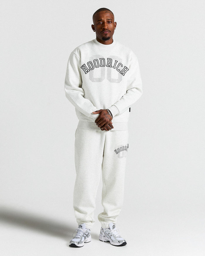 Person wearing a light grey 'Hoodrich' sweatshirt and pants on a plain background