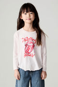 Front view of a girl wearing the Chaser Rolling Stones Luv The Stones Girls Tee on a neutral background with baggy jeans