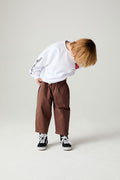 Front view of a boy wearing the Chaser Rolling Stones Pop Tongues Boys Tee on a neutral background looking down at floor