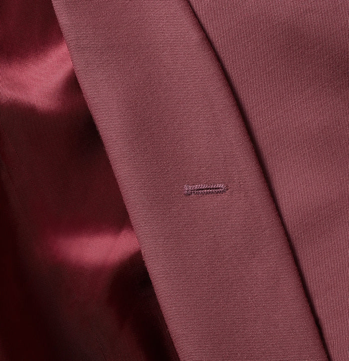 Close-up of dusty rose tuxedo jacket lapel edge and buttonhole detail