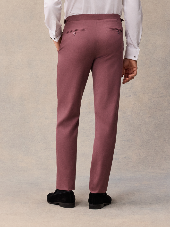 Close-up of man in dusty rose tuxedo trousers, back view, white shirt visible