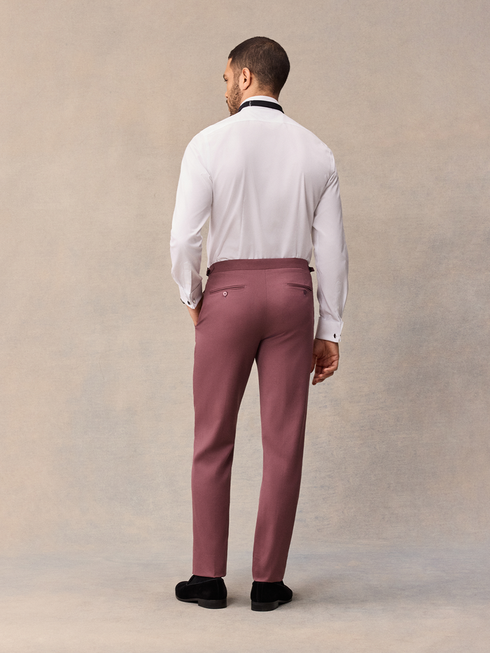 Back view of man in white tuxedo shirt and dusty rose trousers