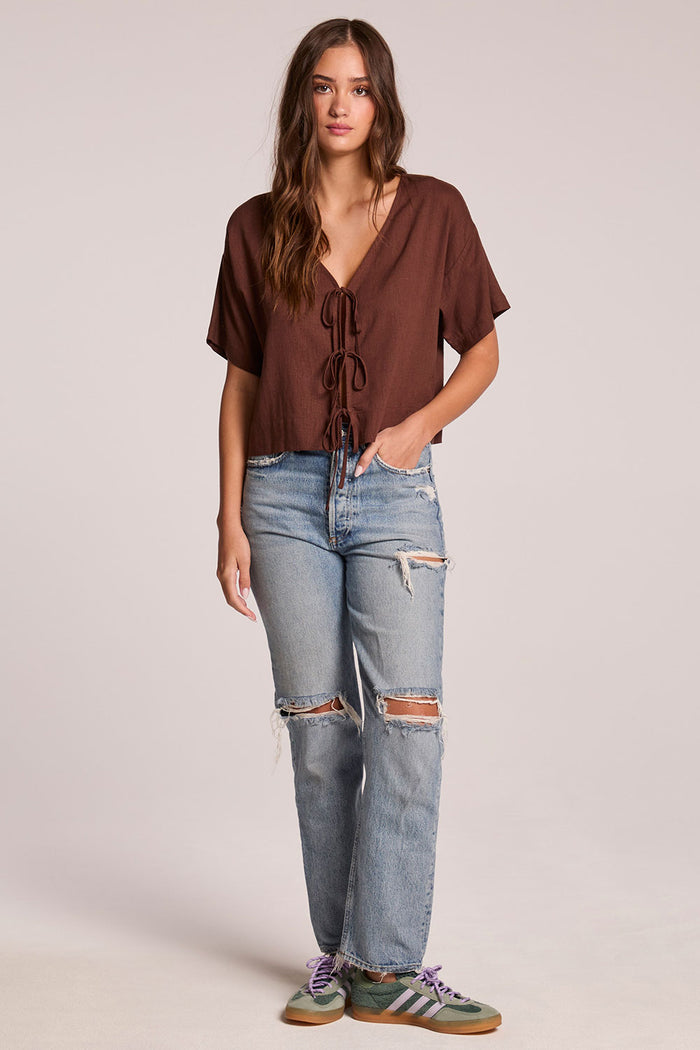 Full body view of a woman wearing the Chaser Roselie Kahlua Blouse and sneakers on a neutral background