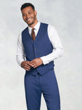 Man in royal blue suit vest and brown tie, smiling, hands clasped