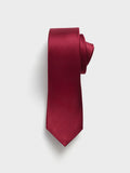 Ruby red necktie with fine diagonal ribbing, rolled on a light grey background.