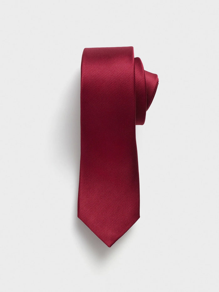 Ruby red necktie with fine diagonal ribbing, rolled on a light grey background.