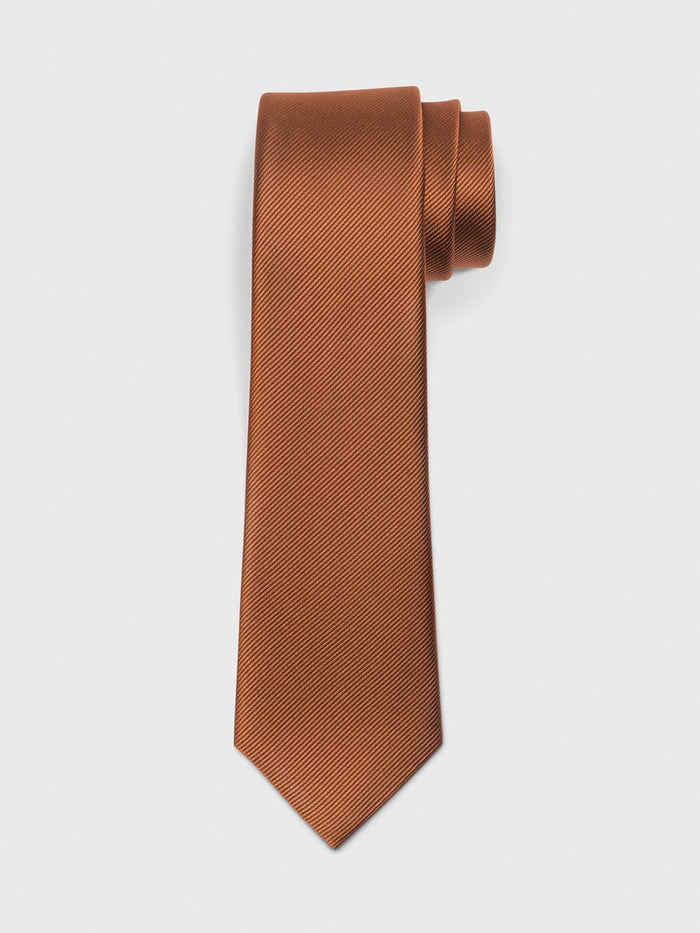 Rust silk necktie rolled at the top on a white background